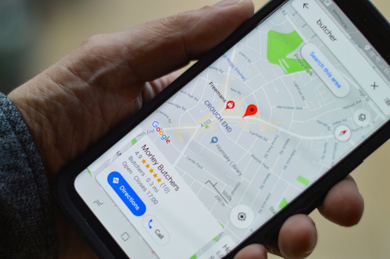 Close-up of a hand holding a smartphone displaying a map app with location pins, symbolizing the importance of venue accessibility for wedding guests.