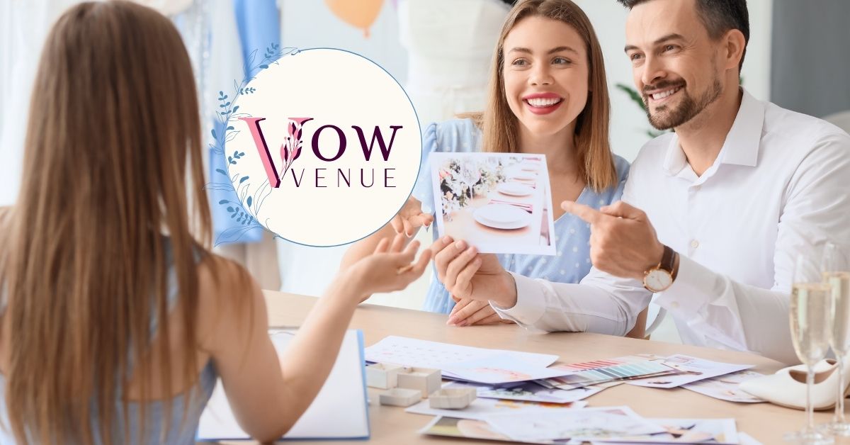 Couple sitting at a desk, with the groom-to-be holding a photo of wedding table place settings. The fiancée smiles, suggesting the caption 'This place setting is perfect!
